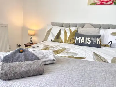 a bedroom with a white bed with pillows on it at Entire holiday home in Blackpool with free parking and a private patio garden in Blackpool