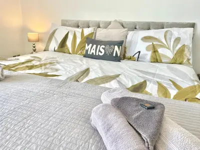 a bedroom with a white bed with a blanket and pillows at Entire holiday home in Blackpool with free parking and a private patio garden in Blackpool