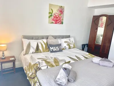 a bedroom with two beds and a table and a mirror at Entire holiday home in Blackpool with free parking and a private patio garden in Blackpool