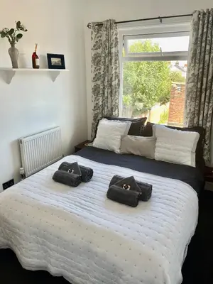 a bedroom with a large bed with two towels on it at Entire holiday home in Blackpool with free parking and a private patio garden in Blackpool