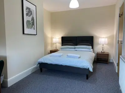 a bedroom with a bed with two lamps on two tables at Be My Guest Liverpool in Liverpool