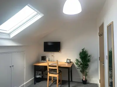 an attic room with a desk and a skylight at Be My Guest Liverpool in Liverpool
