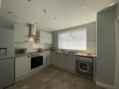 a large kitchen with a washer and dryer in it at Sheil Road Studios - Be My Guest Liverpool in Liverpool