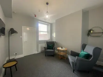 a living room with two chairs and a table at Sheil Road Studios - Be My Guest Liverpool in Liverpool