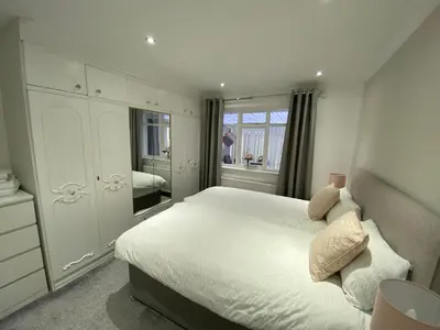 a bedroom with a white bed and a mirror at COLERIDGE LODGE in Thornton