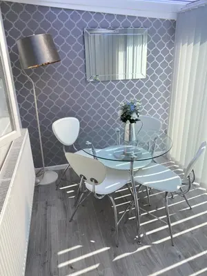 a dining room with a glass table and chairs at COLERIDGE LODGE in Thornton