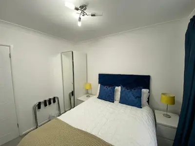 a bedroom with a large bed with blue pillows at COLERIDGE LODGE in Thornton