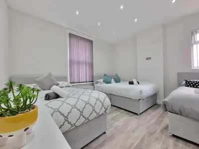 a hotel room with two beds and a couch at DYSA Waterloo Apartments in Blackpool