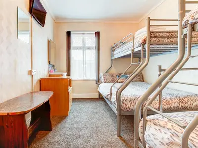 a room with two bunk beds and a desk at Thistle Dhu Guest House in Blackpool