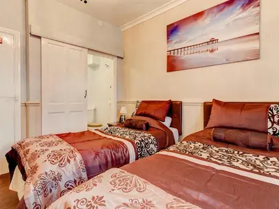 a bedroom with two beds and a painting on the wall at Thistle Dhu Guest House in Blackpool