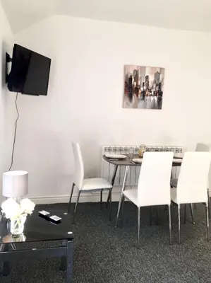 a dining room with a table and white chairs at BELMONT Apartments in Liverpool