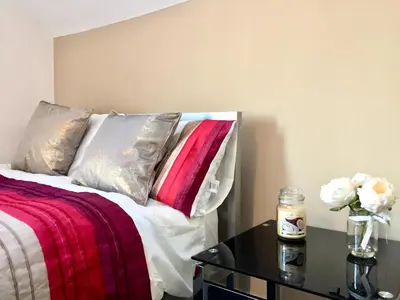a bedroom with a bed and a table with flowers on it at BELMONT Apartments in Liverpool