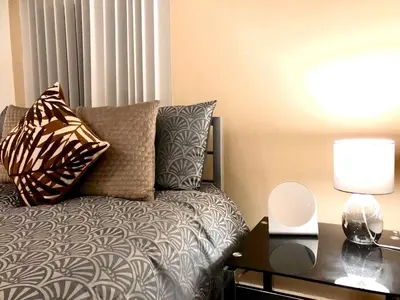 a bedroom with a bed and a table with a lamp at BELMONT Apartments in Liverpool