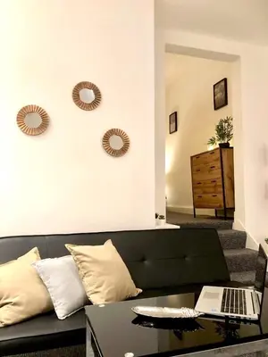 a living room with a black couch and a table at BELMONT Apartments in Liverpool