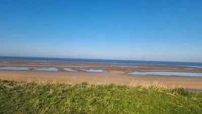 a sandy beach with the ocean in the background at Granada Apartments Queens Mansions in Blackpool
