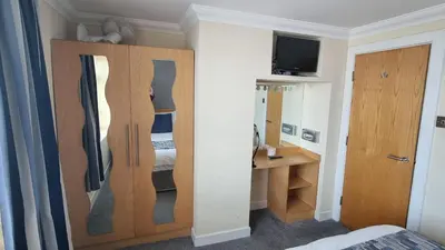 a room with a bedroom with a closet and a bed at Granada Apartments Queens Mansions in Blackpool