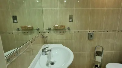 a bathroom with a sink and a mirror at Granada Apartments Queens Mansions in Blackpool