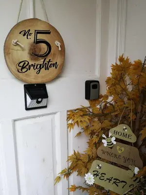a wooden sign on a door with autumn leaves at A home away from home now with Netflix and PS4 in Blackpool