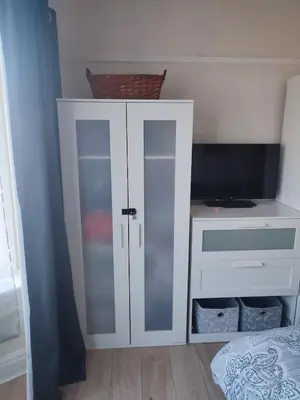 a white cabinet with glass doors in a bedroom at A home away from home now with Netflix and PS4 in Blackpool