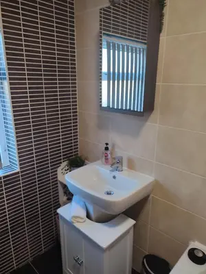 a bathroom with a white sink and a mirror at A home away from home now with Netflix and PS4 in Blackpool