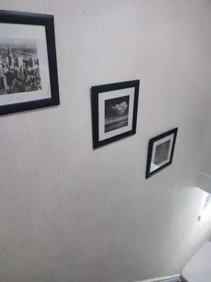 four pictures on a white wall with a lamp at A home away from home now with Netflix and PS4 in Blackpool