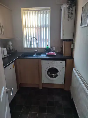 a kitchen with a sink and a washing machine at A home away from home now with Netflix and PS4 in Blackpool