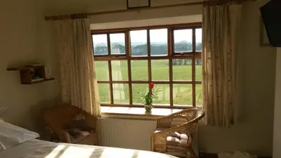 a bedroom with a window with a view of a field at Green Bank Farmhouse in Lancaster