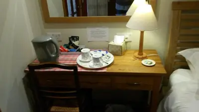 a desk with a lamp and a plate on it at Green Bank Farmhouse in Lancaster