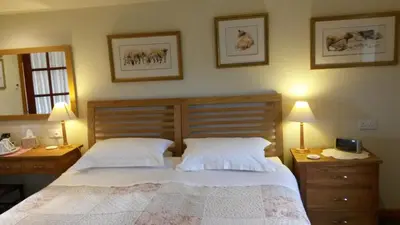 a bedroom with a large bed with two night stands and two lamps at Green Bank Farmhouse in Lancaster