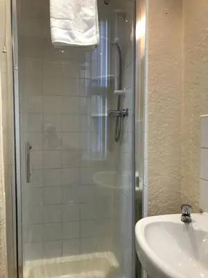 a bathroom with a shower and a sink at Belmont Hotel in Blackpool