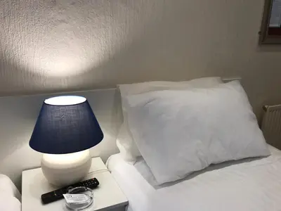 a bed with a white pillow and a lamp on a table at Belmont Hotel in Blackpool