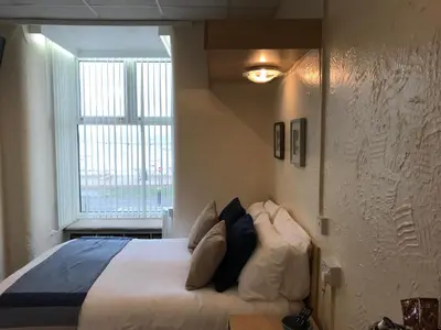 a bedroom with a bed with pillows and a window at Belmont Hotel in Blackpool