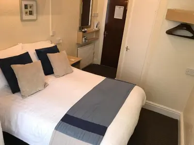 a bedroom with a large white bed with pillows at Belmont Hotel in Blackpool