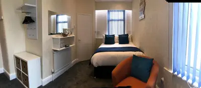 a small room with a bed and a chair in it at Belmont Hotel in Blackpool