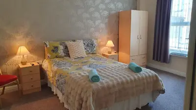 a bedroom with a bed with two blue towels on it at The Tudor in Blackpool