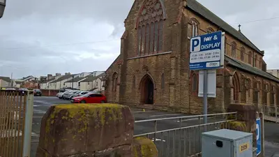 a parking sign in front of a brick church at The Tudor in Blackpool