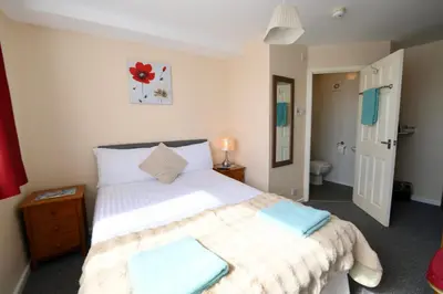 a bedroom with a large bed and a bathroom at The Tudor in Blackpool