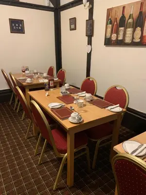 a row of tables and chairs in a room with wine bottles at The Tudor in Blackpool