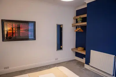 a living room with a blue and white wall at Sapphire House By Sasco in Blackpool