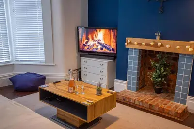 a living room with a tv and a fireplace at Sapphire House By Sasco in Blackpool