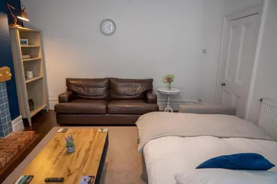 a living room with a couch and a table at Sapphire House By Sasco in Blackpool