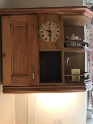 a clock sitting on top of a cabinet at Inglenook Cottage in Grange Over Sands