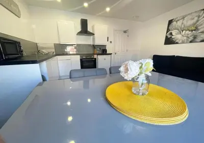 a kitchen with a table with a vase of flowers on it at The Central Suite Blackpool-Best Holiday Letting Home in Blackpool in Blackpool