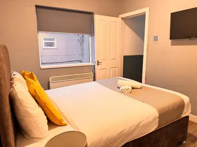 a small bedroom with a bed and a window at The Central Suite Blackpool-Best Holiday Letting Home in Blackpool in Blackpool