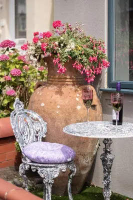 a table with a chair and a vase with flowers at The Mayfield Hotel in Blackpool