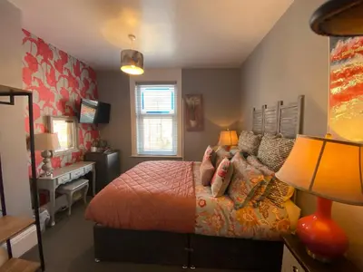 a bedroom with a bed and a desk with a lamp at The Mayfield Hotel in Blackpool