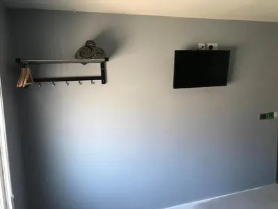 a wall with a tv and a shelf on a wall at Cozy Rooms in Liverpool
