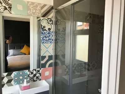 a bathroom with a glass shower with a bed in it at Cozy Rooms in Liverpool