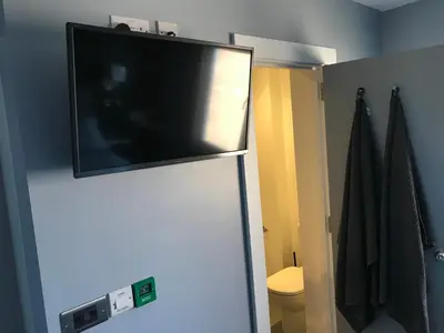 a flat screen tv on top of a refrigerator at Cozy Rooms in Liverpool