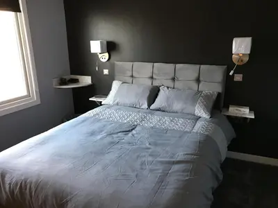 a bedroom with a large bed with a white bedspread at Cozy Rooms in Liverpool